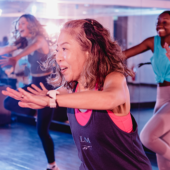 Three women in a fitness gym during aerobics.