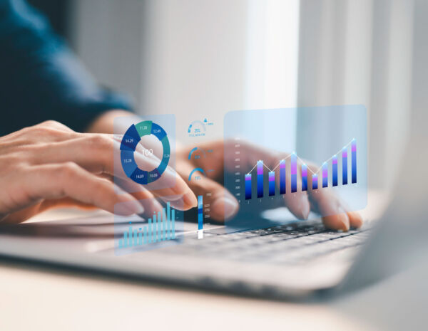 Hands typing on a laptop with digital computing graphics overlay, symbolizing strategies for reducing IT costs through cloud printing.