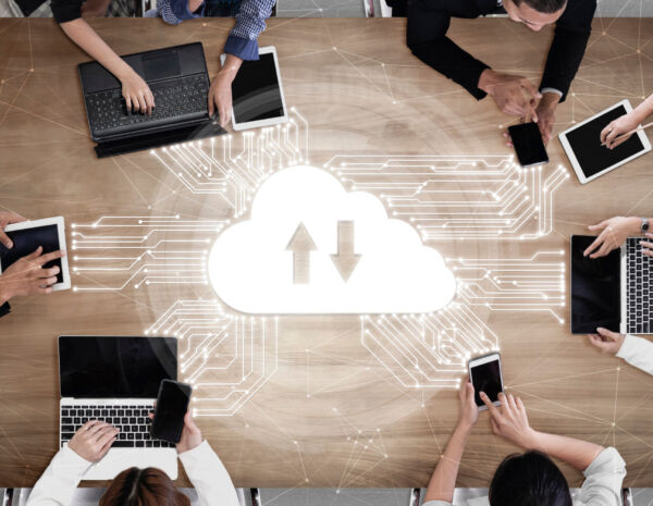 Top-down view of a group collaborating at a table, using devices, with a cloud icon and data connections illustrating seamless mobile printing integration.