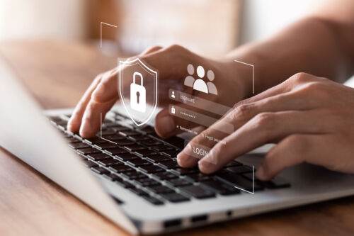 Hands typing on a laptop displaying a virtual authorization lock screen requesting a username and password, demonstrating the importance of secure printing solutions.